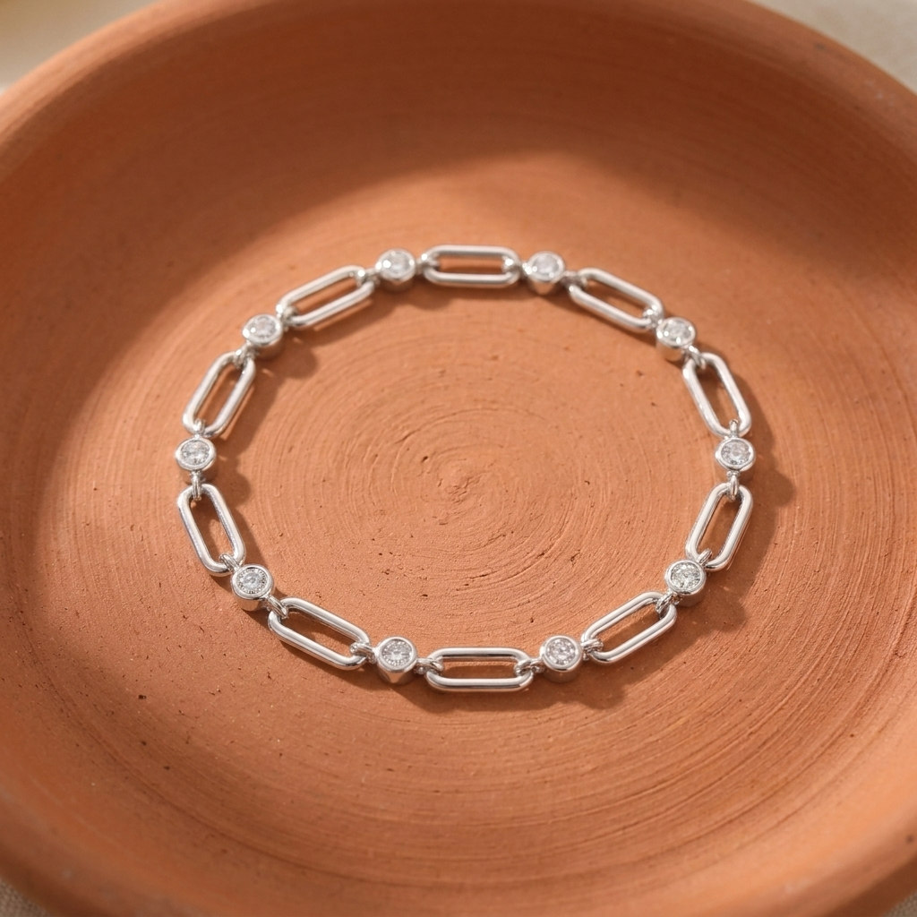 Pulsera de plata 925 con eslabones tipo paperclip y una circonita redonda en cada unión, sobre plato de cerámica