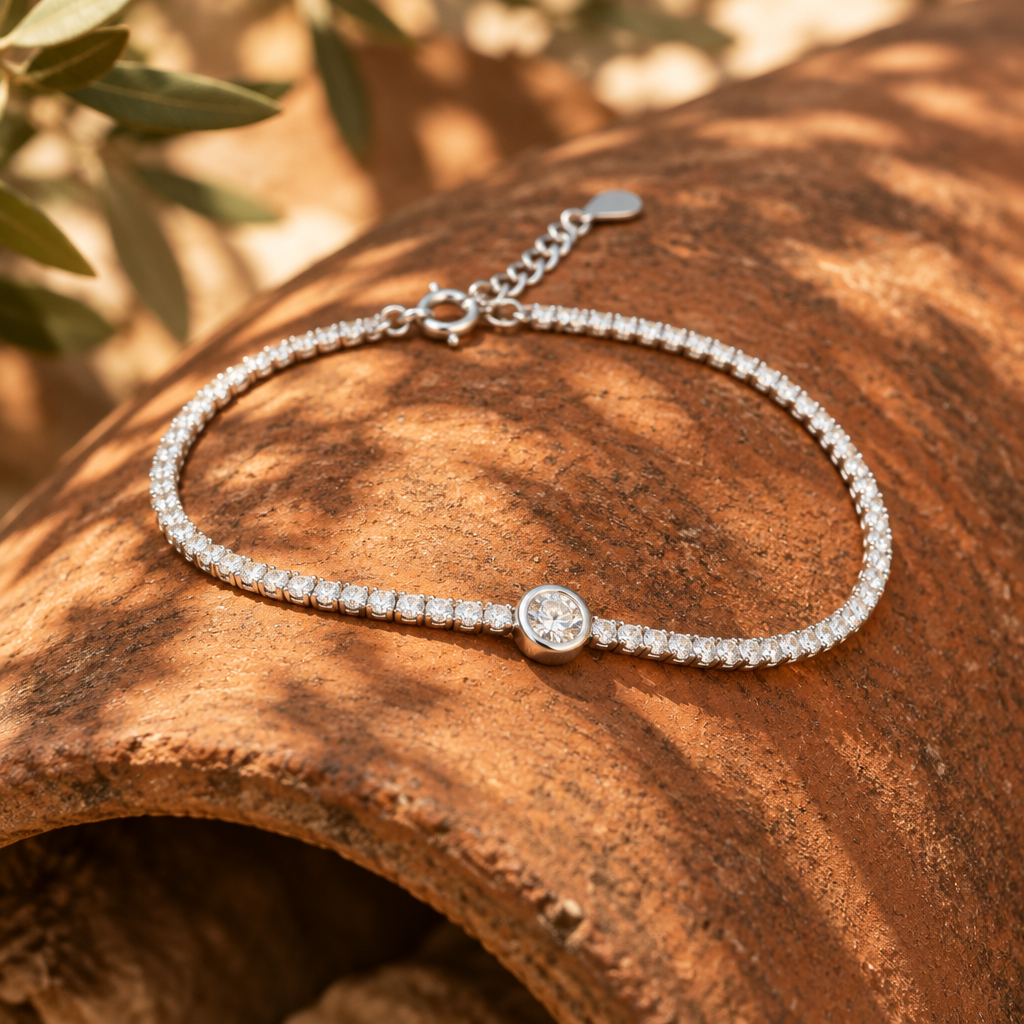 Pulsera tenis de plata 925 con una hilera de piedras transparentes y un punto de luz central en chatón liso, sobre una teja de terracota